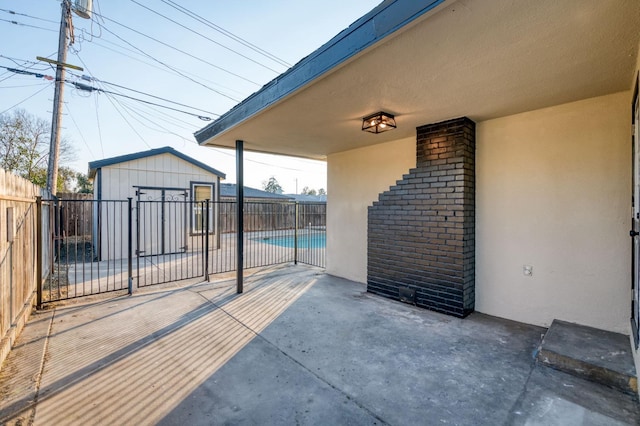 view of patio with a fenced in pool and a storage unit