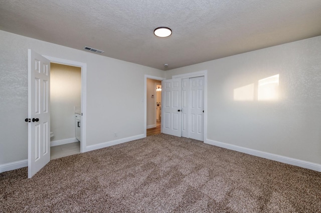 unfurnished bedroom featuring carpet floors, a closet, and a textured ceiling