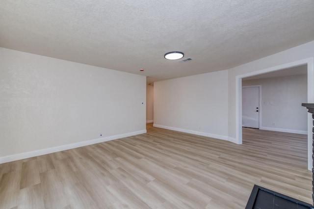 interior space with a textured ceiling and light hardwood / wood-style flooring