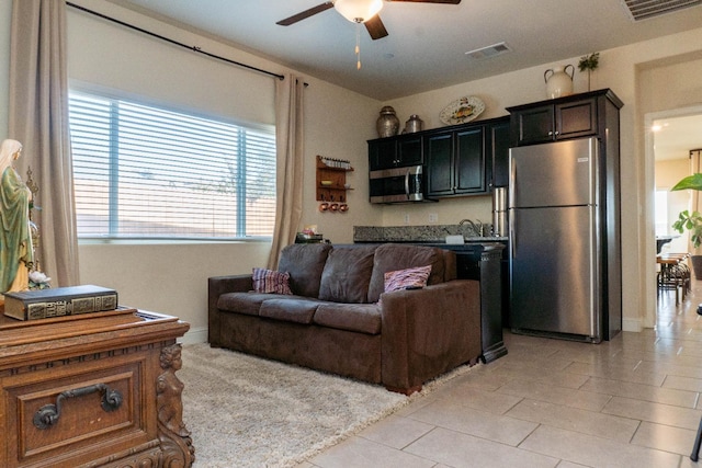 living room featuring light tile patterned flooring and ceiling fan