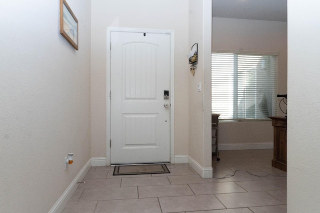 doorway to outside with light tile patterned floors