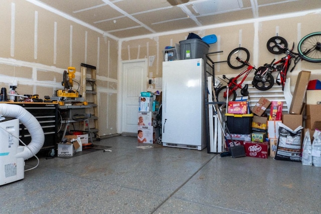 garage with white fridge and a workshop area