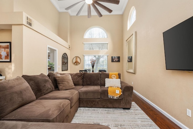 living room featuring hardwood / wood-style floors, ceiling fan, and a high ceiling