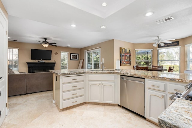 kitchen with sink, stainless steel dishwasher, white cabinets, and light stone countertops