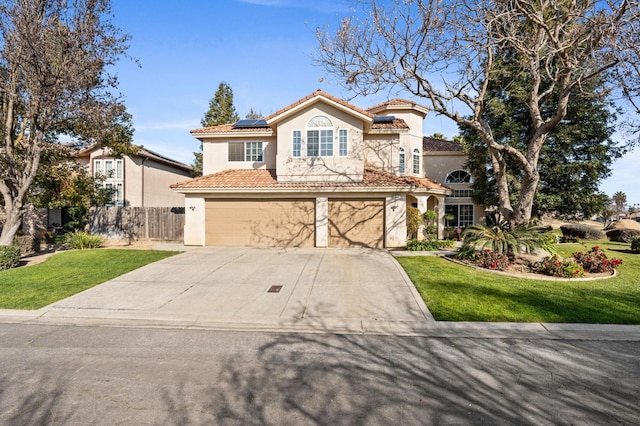 mediterranean / spanish-style home featuring a garage, a front yard, and solar panels