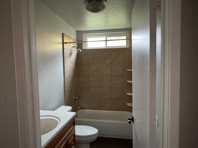 full bath with a textured wall, toilet,  shower combination, a textured ceiling, and vanity