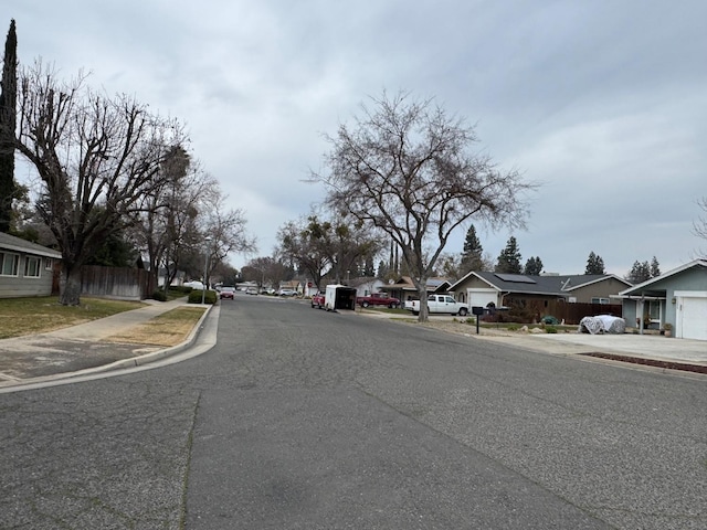 view of street featuring a residential view, curbs, and sidewalks