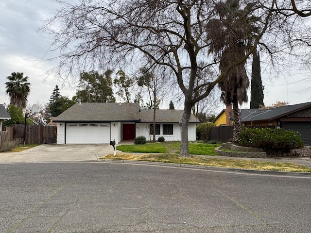 ranch-style home with an attached garage, driveway, fence, and a front yard