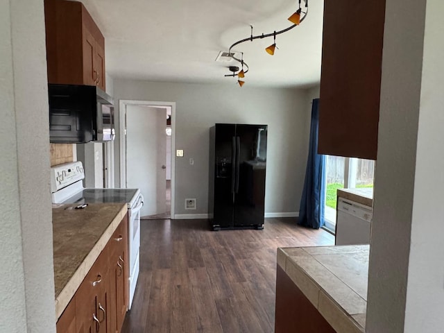 kitchen featuring dark wood finished floors, visible vents, brown cabinetry, white appliances, and baseboards