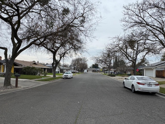 view of street featuring curbs, sidewalks, and a residential view