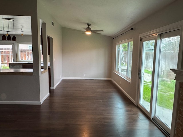 empty room featuring vaulted ceiling, ceiling fan, dark wood-type flooring, and baseboards