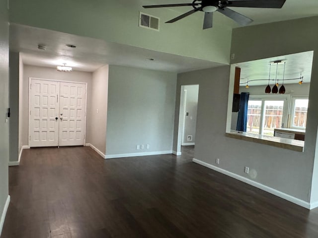 interior space featuring dark wood-style floors, baseboards, visible vents, and ceiling fan