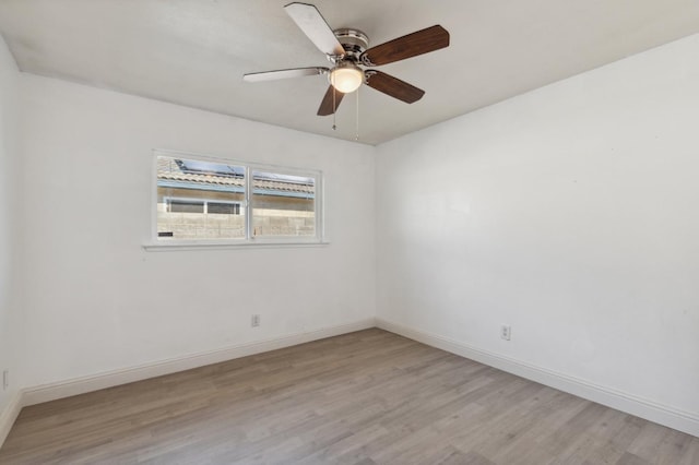 unfurnished room featuring baseboards and light wood-style floors