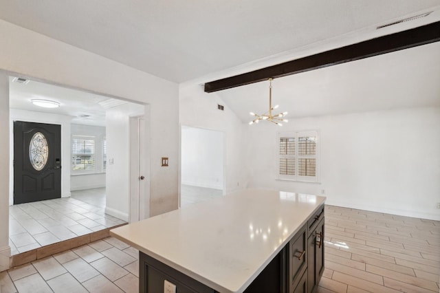 kitchen with visible vents, lofted ceiling with beams, a kitchen island, open floor plan, and light countertops