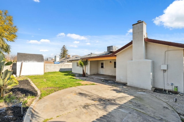 back of house with a yard, a patio, a shed, a fenced backyard, and an outdoor structure