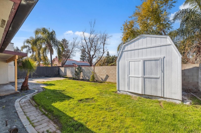 view of yard featuring a fenced backyard, an outdoor structure, and a shed