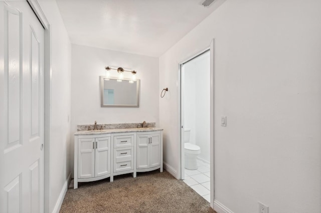 full bath with toilet, double vanity, carpet floors, and a sink