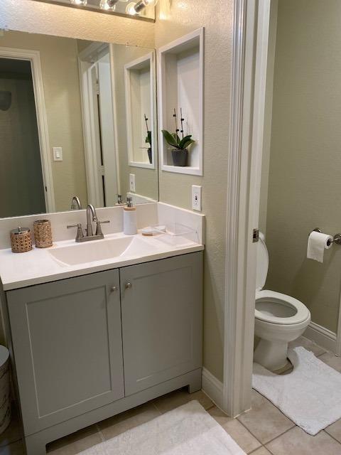 bathroom featuring vanity, tile patterned floors, and toilet