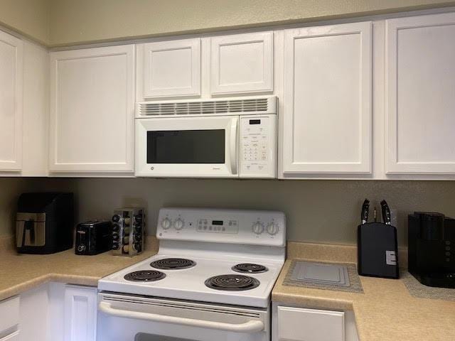 kitchen with white cabinets and white appliances