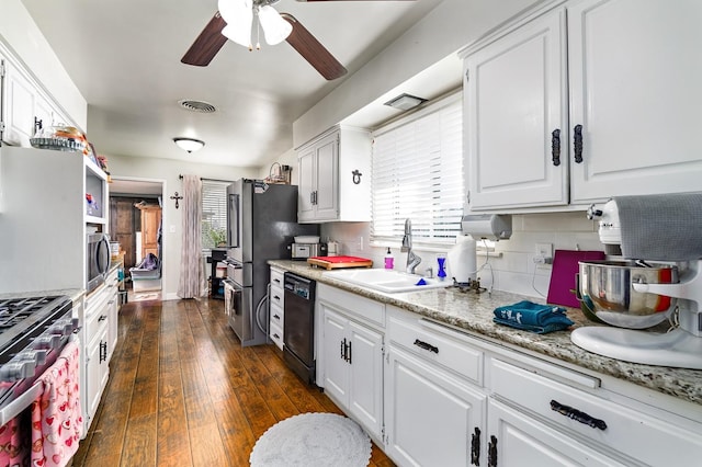 kitchen with white cabinetry, sink, backsplash, stainless steel appliances, and dark wood-type flooring