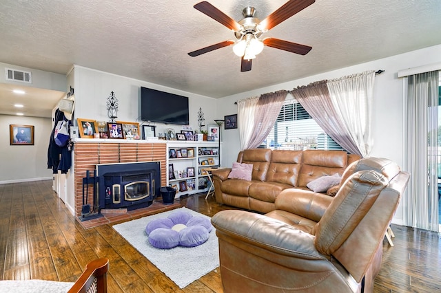 living room featuring ceiling fan, dark hardwood / wood-style floors, and a textured ceiling