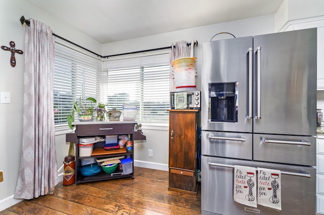 kitchen featuring high end fridge and dark wood-type flooring