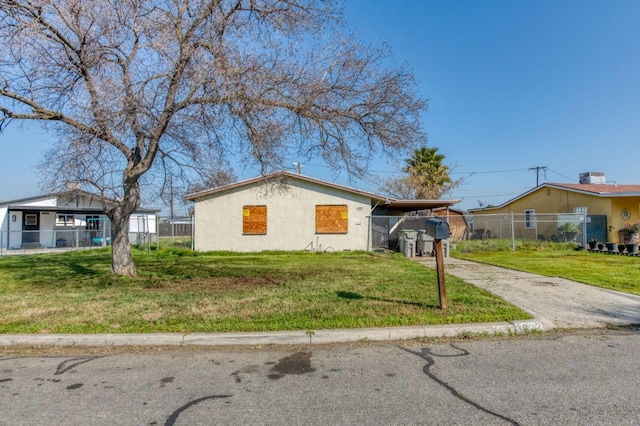 ranch-style home featuring a carport and a front yard