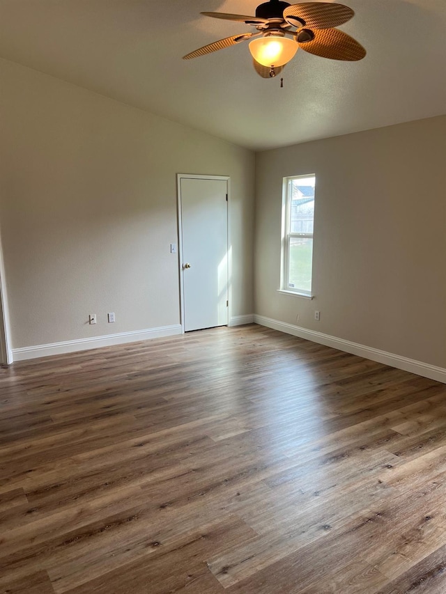 unfurnished room with dark wood-type flooring and ceiling fan