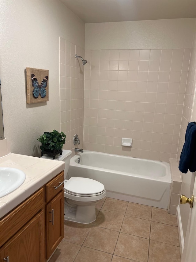 full bathroom featuring vanity, toilet, tiled shower / bath combo, and tile patterned flooring