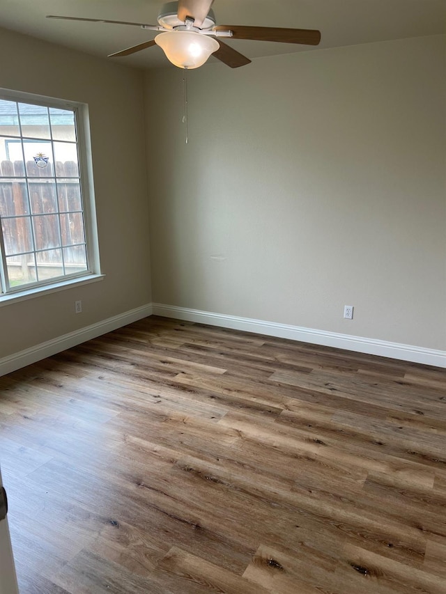 empty room with ceiling fan and light hardwood / wood-style flooring