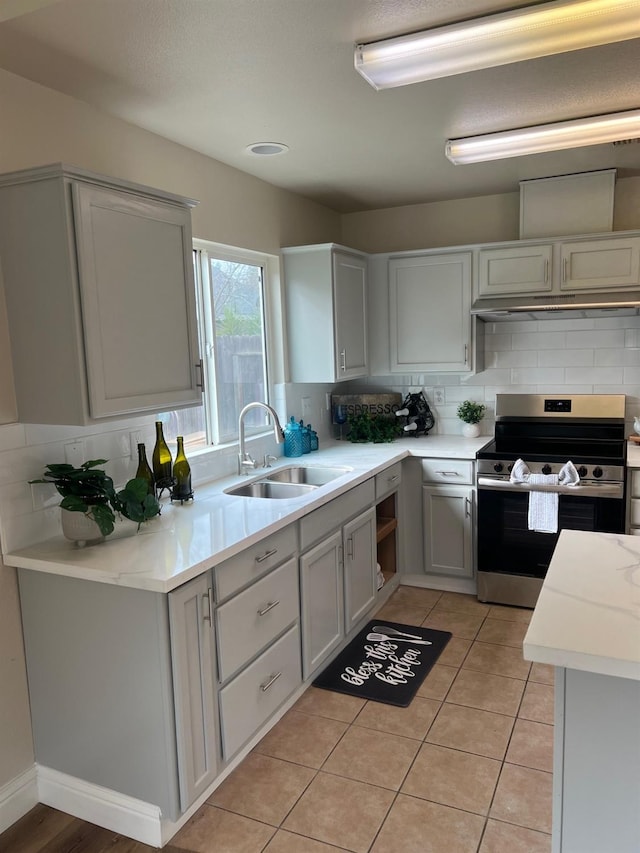 kitchen featuring decorative backsplash, sink, stainless steel electric range, and light tile patterned floors