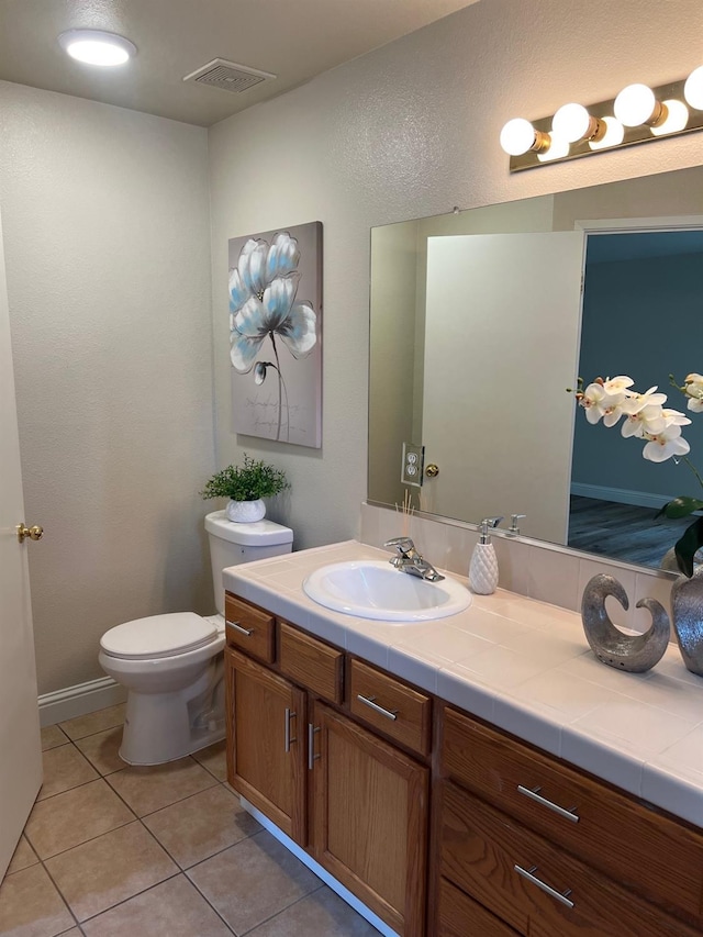 bathroom featuring vanity, toilet, and tile patterned flooring