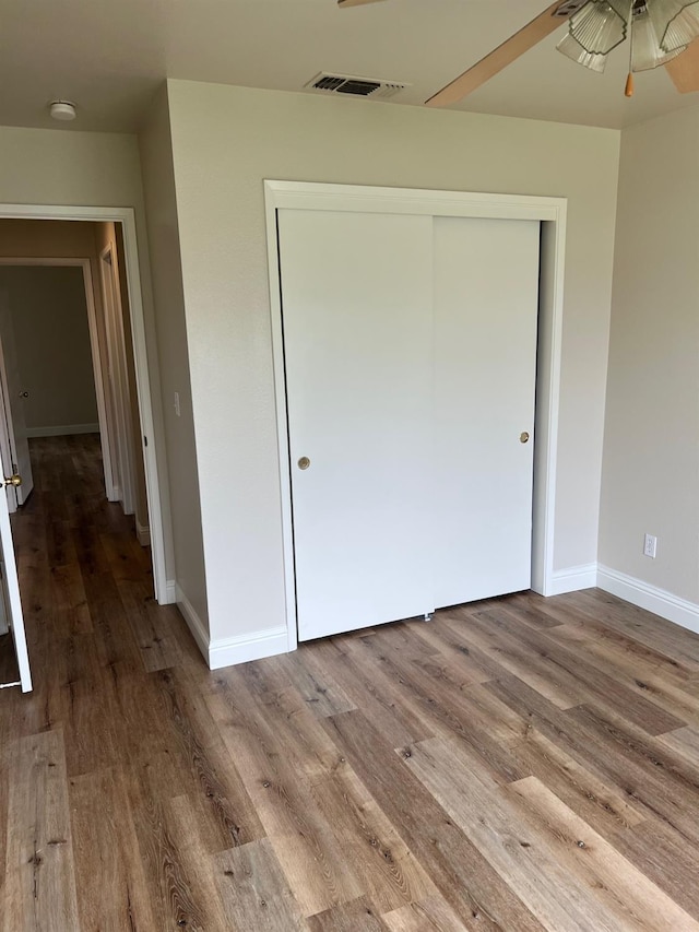 unfurnished bedroom with hardwood / wood-style flooring and a closet