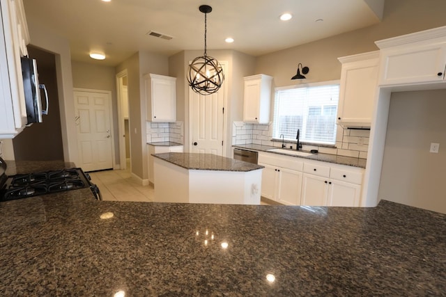 kitchen featuring stainless steel appliances, sink, pendant lighting, and white cabinets