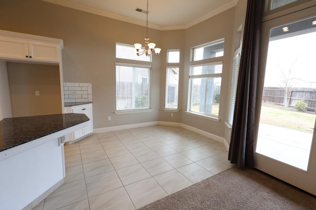 unfurnished dining area featuring ornamental molding, a chandelier, light tile patterned floors, and a wealth of natural light