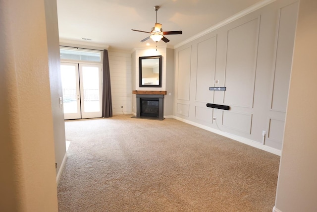 unfurnished living room featuring ornamental molding, light colored carpet, and ceiling fan