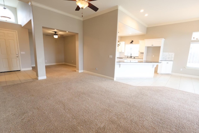 unfurnished living room with crown molding, light colored carpet, and ceiling fan