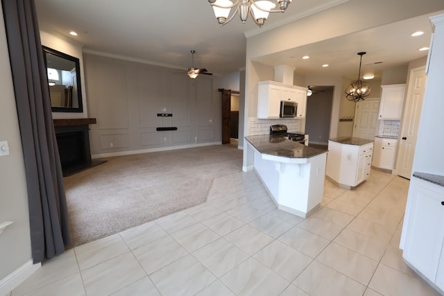 kitchen with white cabinetry, appliances with stainless steel finishes, a barn door, and light carpet