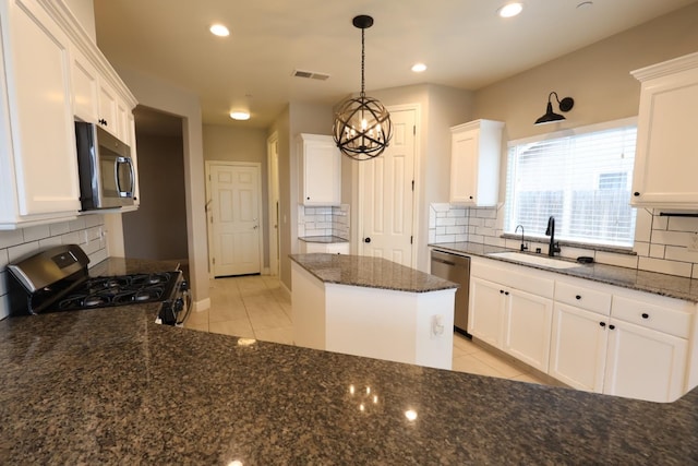 kitchen with sink, decorative light fixtures, light tile patterned floors, stainless steel appliances, and white cabinets