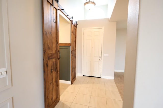 corridor with light tile patterned flooring and a barn door