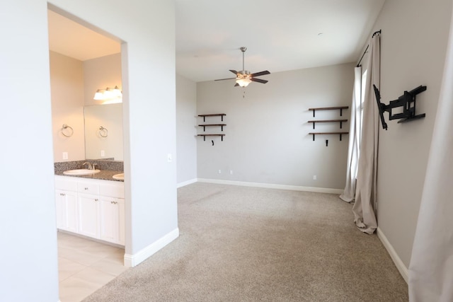 unfurnished room with light carpet, sink, and ceiling fan