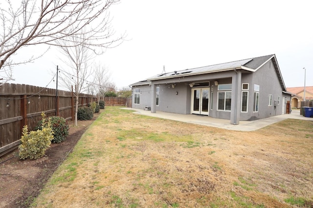 back of property with a patio area and a lawn