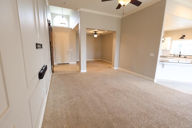 unfurnished living room with ornamental molding, light colored carpet, and ceiling fan