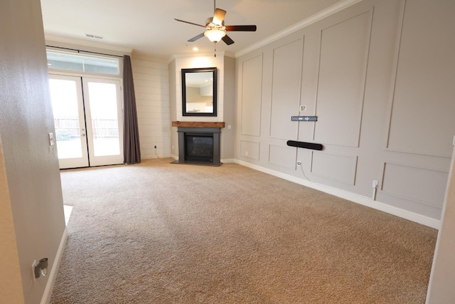 unfurnished living room with ornamental molding, light colored carpet, french doors, and ceiling fan