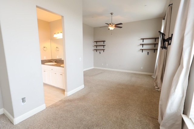 empty room with ceiling fan, light colored carpet, and sink