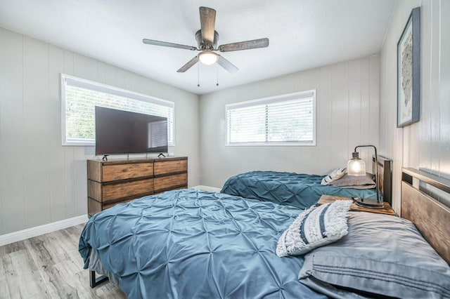 bedroom featuring multiple windows, ceiling fan, and light wood-type flooring