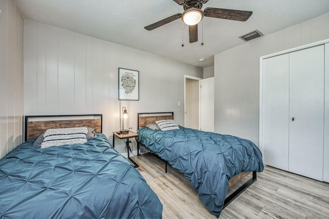 bedroom featuring ceiling fan, a closet, and light hardwood / wood-style flooring