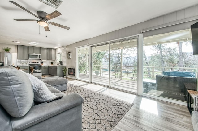 living room with ceiling fan and light hardwood / wood-style flooring