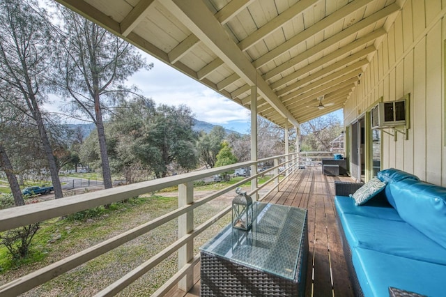 exterior space with outdoor lounge area and a wall mounted air conditioner