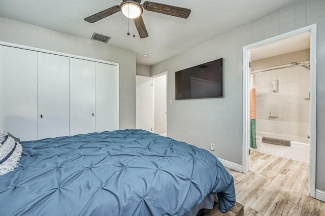 bedroom featuring ceiling fan, connected bathroom, a closet, and light wood-type flooring